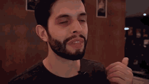 a man with a beard is making a funny face with his eyes closed