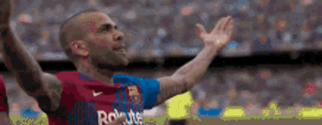 a man in a soccer uniform is raising his hands in the air
