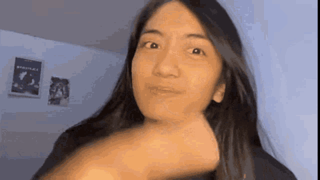 a woman with long hair is making a funny face .