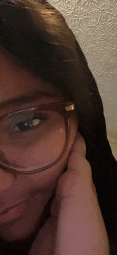 a close up of a woman wearing glasses with her hand on her face