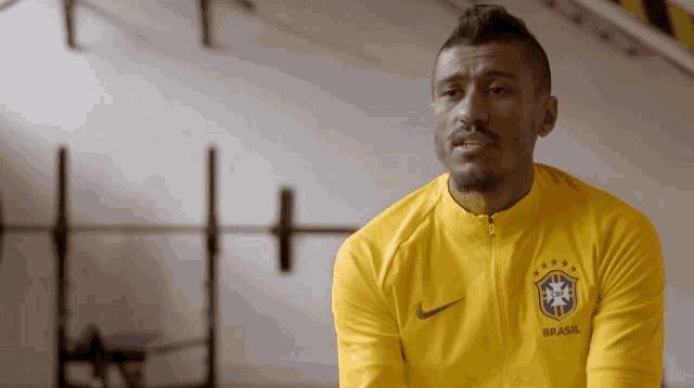 a man wearing a yellow jacket with the word brasil on the front