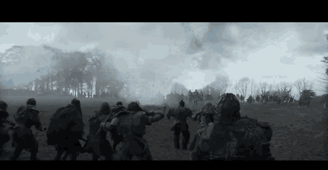 a group of soldiers are standing in a field with smoke coming out of the trees