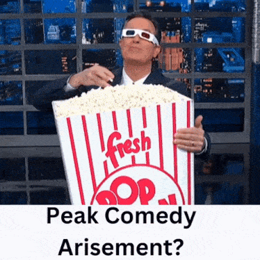 a man wearing 3d glasses is holding a bucket of fresh pop corn