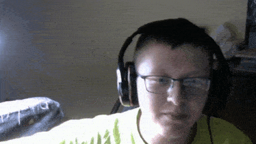 a young man wearing headphones and glasses is looking at the camera