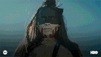 a woman with long hair and a mask on her face is standing in front of a blue sky .