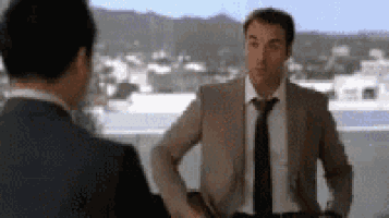 a man in a suit and tie is talking to another man in a suit .