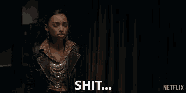 a woman in a leather jacket says shit in front of a curtain
