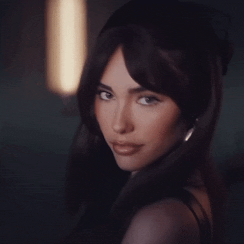 a woman with long dark hair looks at the camera