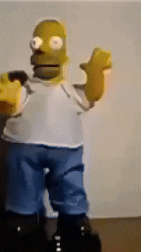 a homer simpson toy is standing in front of a wall