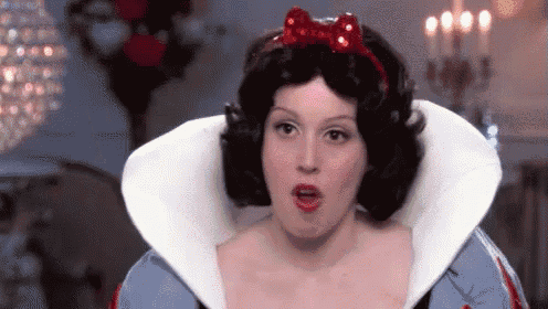 a woman is dressed as snow white from snow white and the seven dwarfs and is making a funny face .