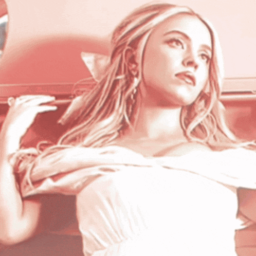 a woman in a white dress is laying on a red chair
