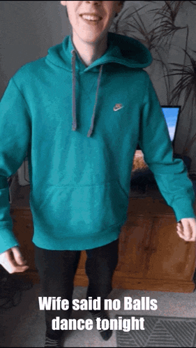 a man in a teal nike hoodie is dancing