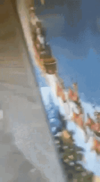 a blurred image of a roller coaster with people on it