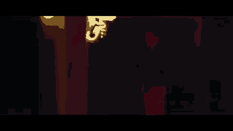 a man in a black shirt is standing in a dark hallway .