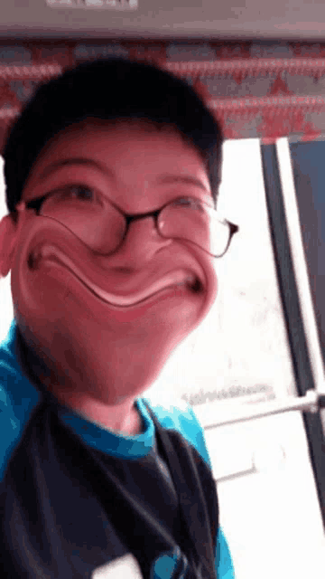 a boy wearing glasses makes a funny face