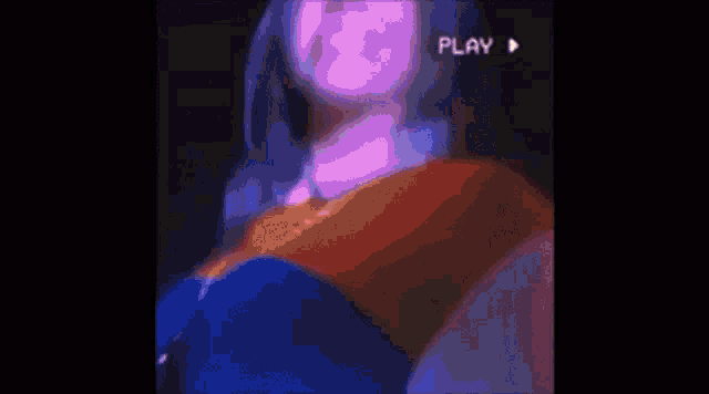 a woman in a red and blue dress is dancing on a stage with a purple background .