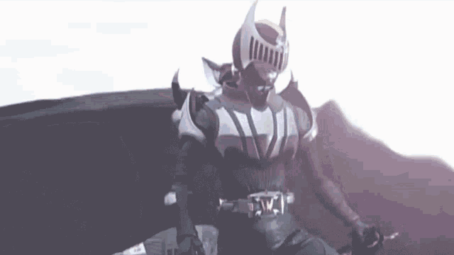 a man in a superhero costume is holding a sword .