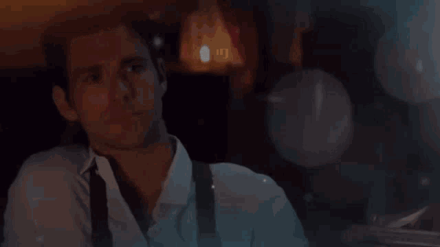 a man in a white shirt and black tie is looking at the camera