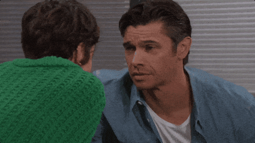 a man in a green sweater hugging a woman in a green sweater