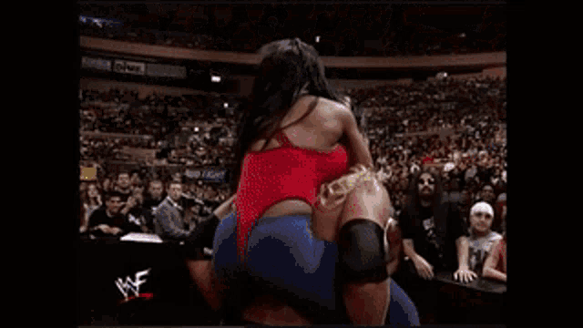 a wrestling match is being shown on a screen with the letters wwe on it