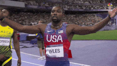 a man wearing a usa shirt stands on a track