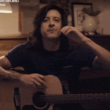 a man is playing an acoustic guitar in front of a sign that says ' music '