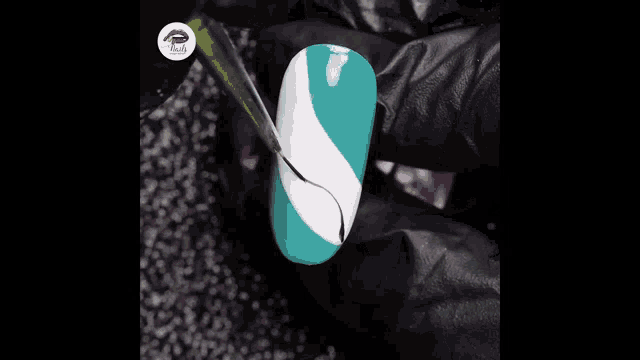 a person is painting a nail with a brush