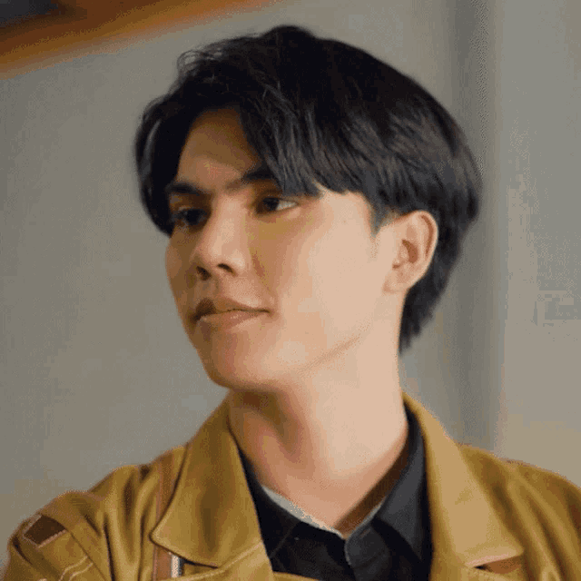 a close up of a young man 's face with a yellow jacket on