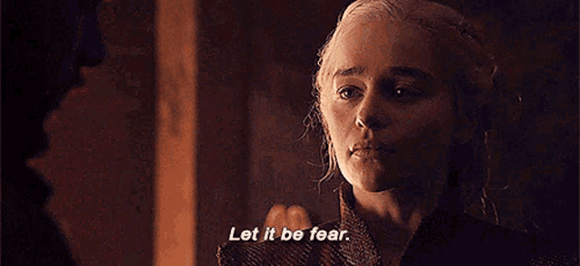 a woman is talking to a man in a room and saying `` let it be fear '' .