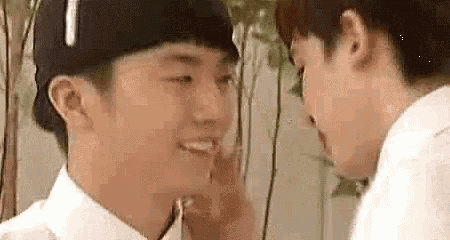 two men are touching each other 's faces .