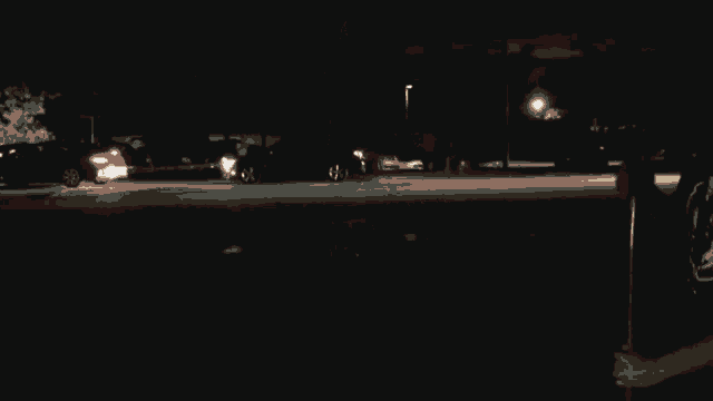 a blurry picture of a street at night with cars driving by