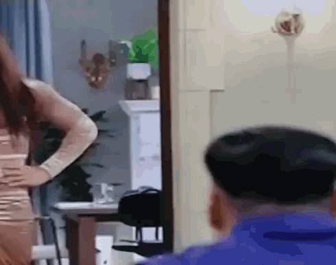 a man and a woman are standing in front of a mirror in a room .