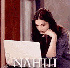 a woman is sitting in front of a laptop with the word nahiii written on the screen