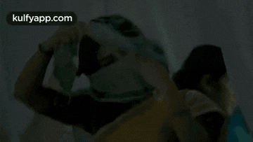 a woman is holding a cloth in front of her face .