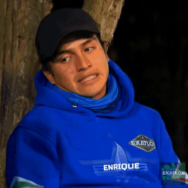 a man wearing a blue enrique exatlon hoodie