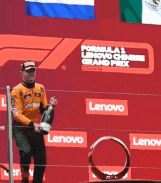 a man stands on a stage with a sign that says formula 1