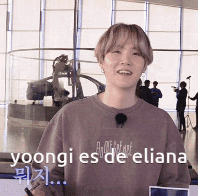 a young man wearing a sweatshirt that says ' yoongi es de eliana ' on it