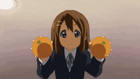 a girl is holding two oranges in her hands
