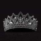 a silver tiara with diamonds on a black background .