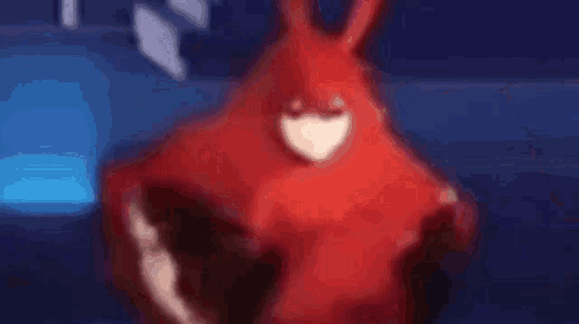 a close up of a person 's hand holding a red object in a blurry photo .