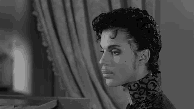 a black and white photo of prince with the words yes behind him