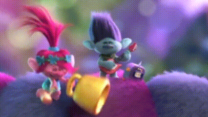 a couple of trolls standing next to each other on a purple surface .