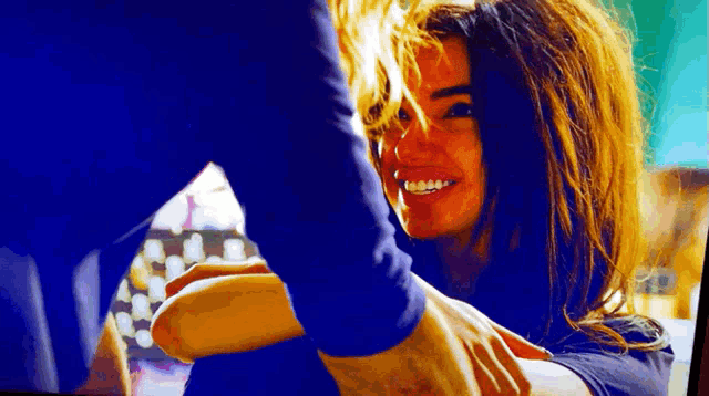 a woman is smiling while holding a man 's hand