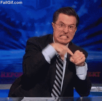 a man in a suit and tie is making a funny face and pointing at the camera