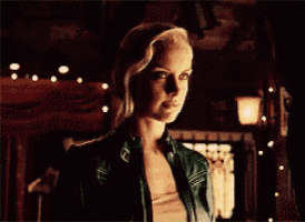 a woman in a green leather jacket is looking at the camera