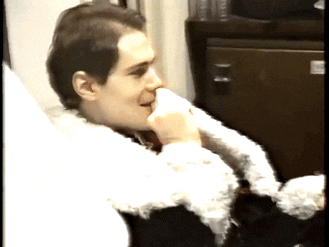 a man in a fur coat is sitting in front of a cabinet