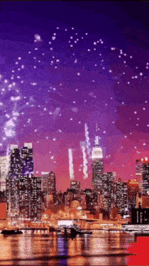 fireworks are displayed over a city skyline with the empire state building in the foreground