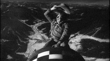 a black and white photo of a man in a cowboy hat riding a motorcycle