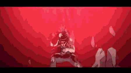 a man is standing in a dark room with a red background .