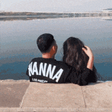a man and a woman are looking at a body of water